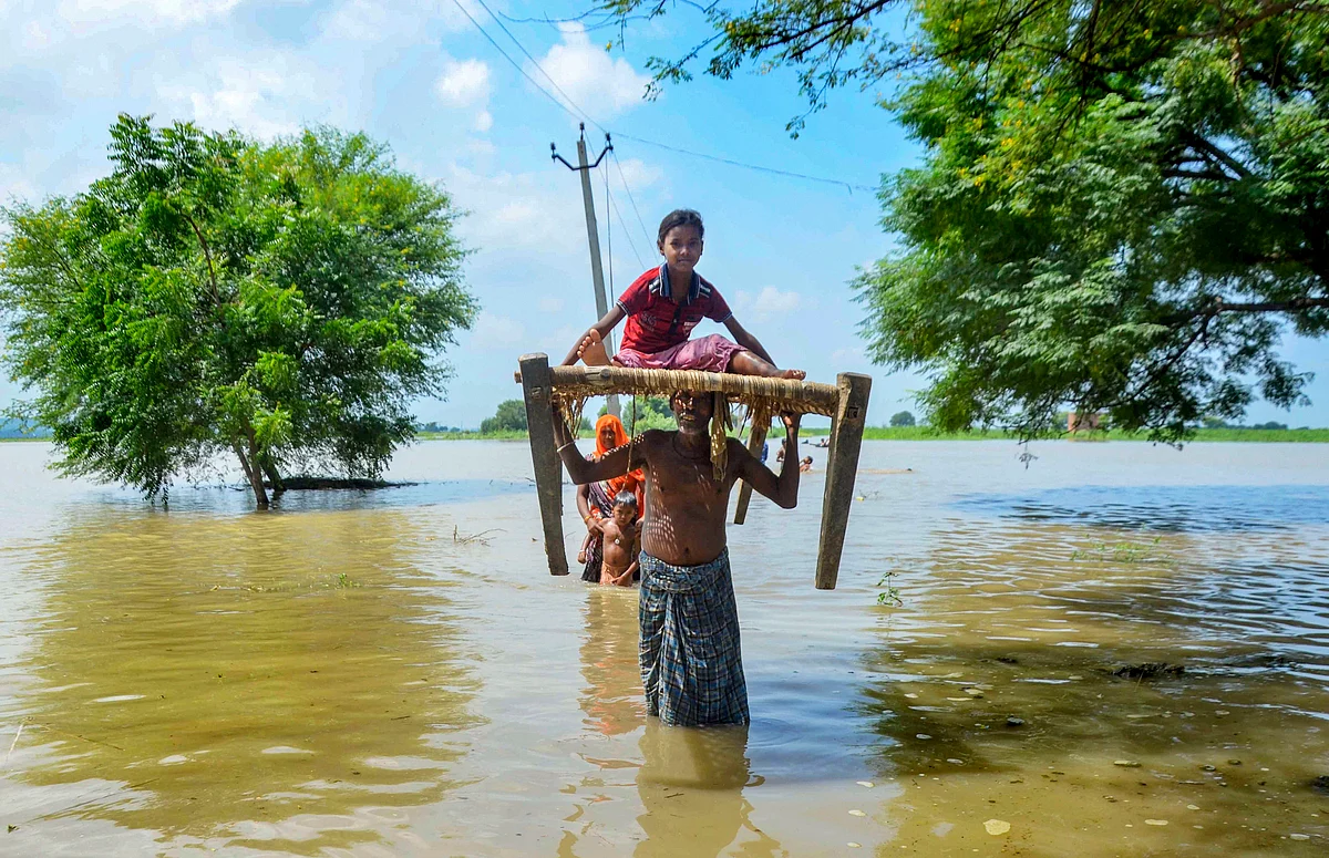 Villagers relocate to a safer place after their houses get flooded due to River Ganga rising following monsoon rainfall, at Narsinghpur village in Mirzapur.