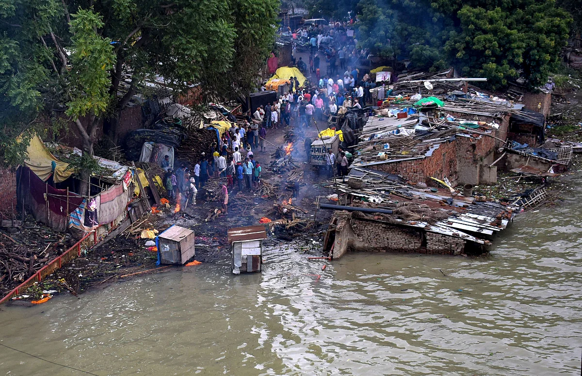 Cremation being performed at a street following rise in the water level of River Ganga, inundating the low lying areas, in Prayagraj. 