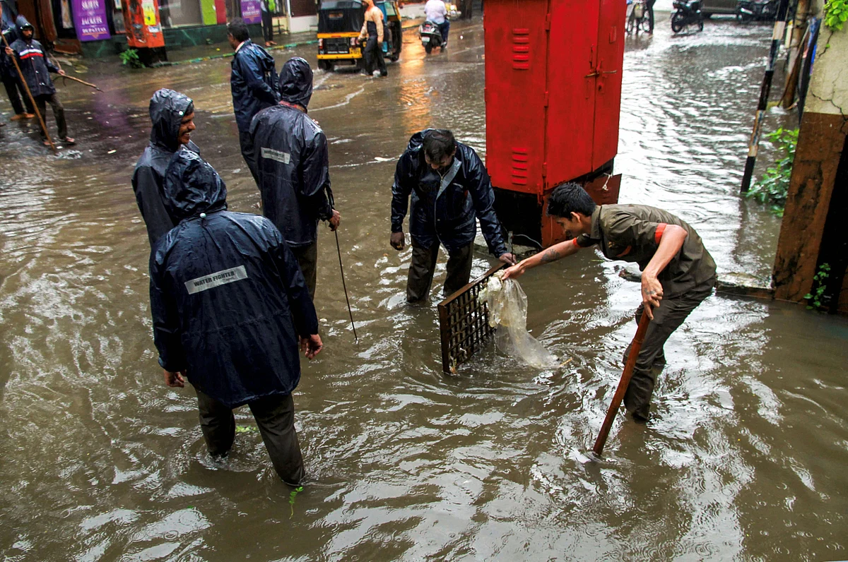 <b> Municipality workers unclog a drain following heavy monsoon rains in Thane on 4 September.</b>