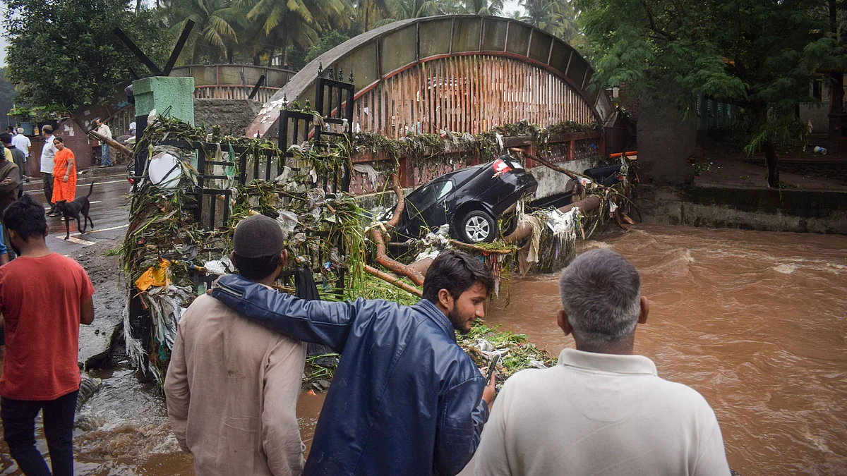 Residents look at the vehicles that got washed away in floodwater following heavy rains, at Sahakar Nagar locality in Pune, on Wednesday, 25 September 2019. 