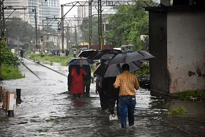 Mumbai: Commuters trudge flooded railway tracks after sunurban trains of Western Railway were paralysed in Mumbai on Sep 4, 2019. The Western Railway (WR) had to suspended suburban and long distance services on the Vasai-Virar sector (Palghar) after the railway tracks were submerged under over three feet water. (Photo: IANS)