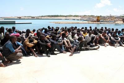 QARA BOLLE, July 17, 2014 (Xinhua) -- Some illegal immigrants sit on the ground after being rescued off the coast of Qara Bolle, in Libya, on July 17. Libya