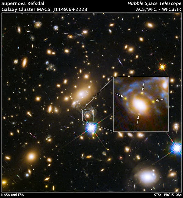 A large cluster galaxy (centre of the box) has split the light from an exploding background supernova into four yellow images/dots.