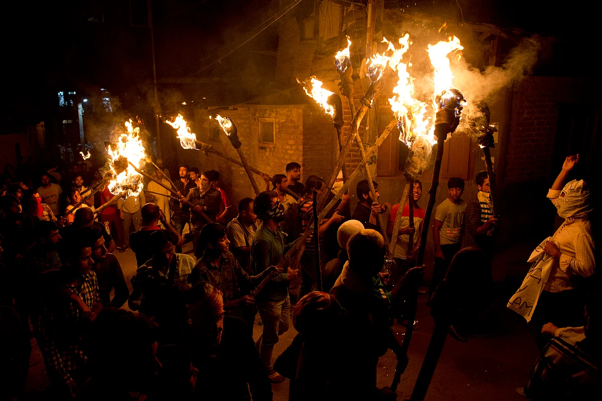 Kashmiri men shout slogans during a torch light march urging world leaders to protest the decision to strip Jammu and Kashmir of semi-autonomy and statehood, in Srinagar, Thursday, 26 September.