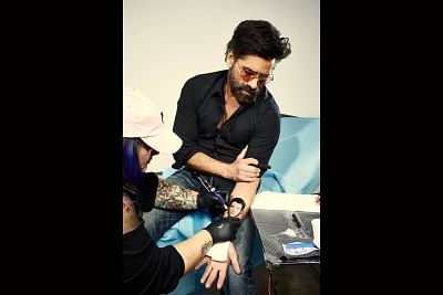Actor John Stamos upped the stakes in his prank battle with Nick Jonas, as he posted a photograph of himself seemingly getting a tattoo of the singer
