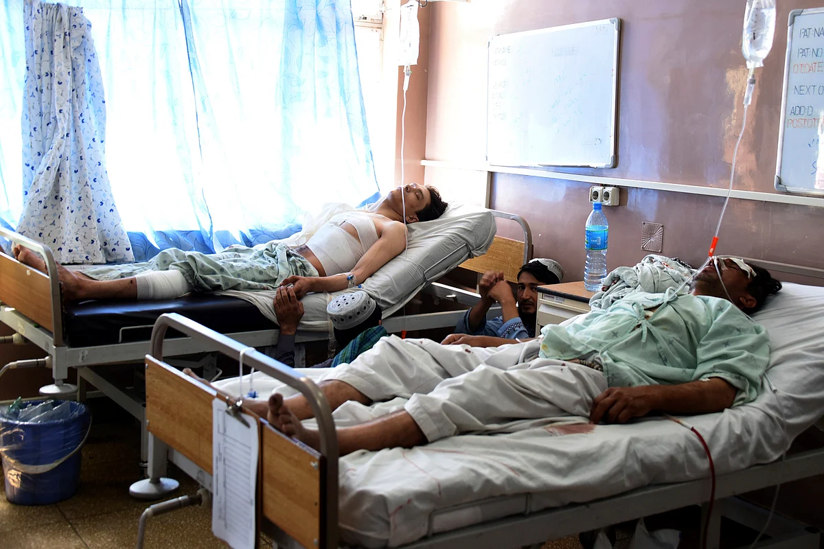 Wounded Afghans lie on a bed at a hospital after a bomb attack on a local mosque in Kandahar province, south of Kabul, Afghanistan.