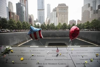 NEW YORK, Sept. 12, 2018 (Xinhua) -- Flowers and balloons are placed on plates on which the names of 9/11 victims were inscribed around the South Pool at the National September 11 Memorial and Museum in New York, the United States, Sept. 11, 2018. Thousands of people came here on Tuesday to memorize the victims of the 9/11 terror attacks which happened 17 years ago and claimed thousands of lives. (Xinhua/Wang Ying/IANS)
