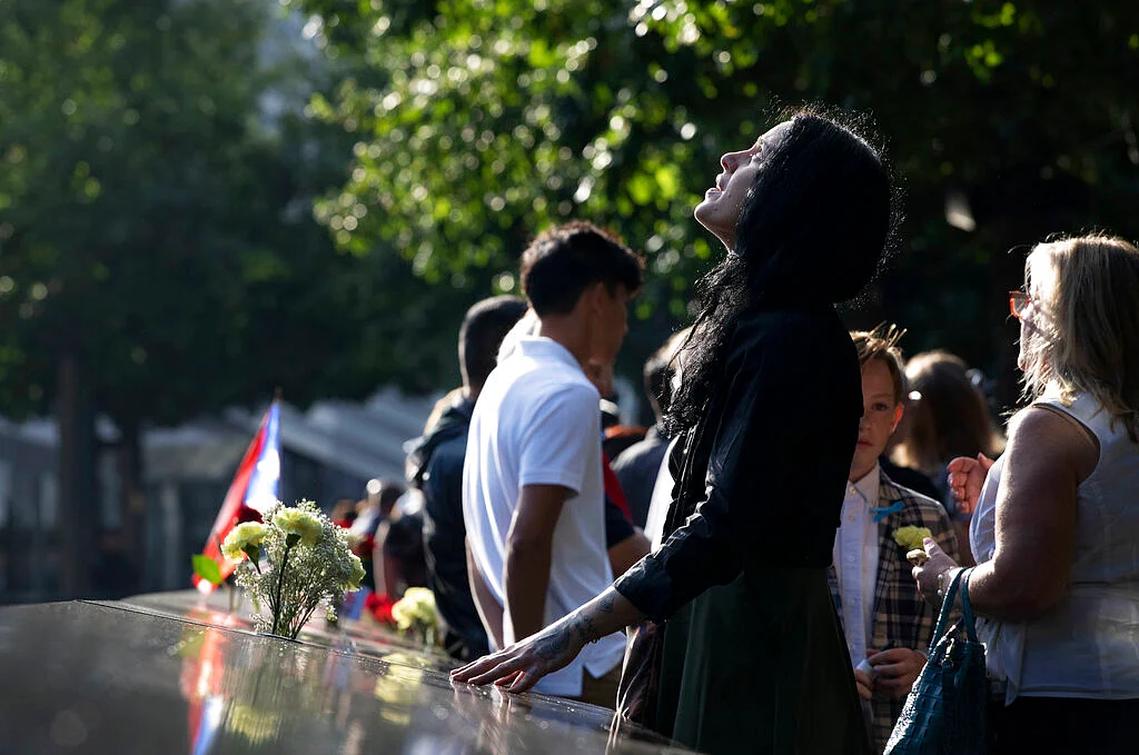 A woman stands next to the north pool prior to a ceremony marking the 18th anniversary of the 11 September attacks at the National September 11 Memorial in New York. 