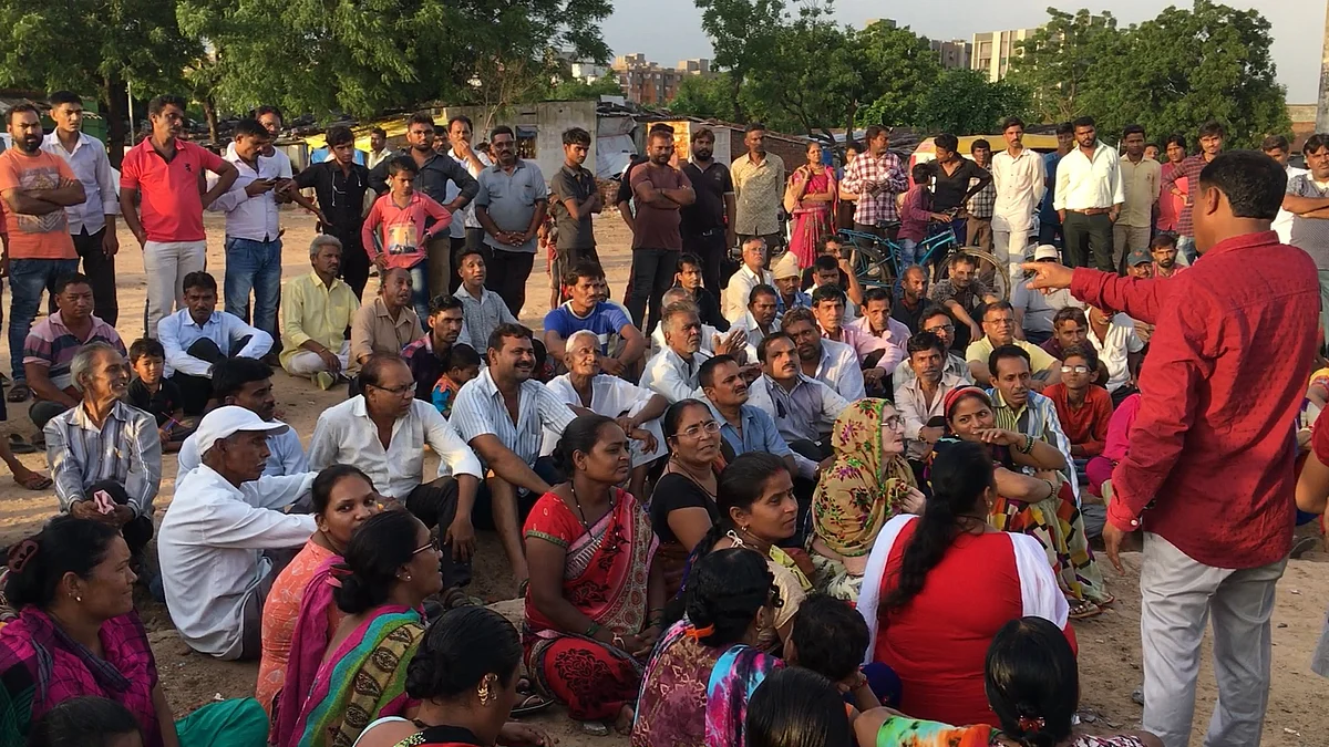 Members of RDAM speak with the now homeless residents of the low income housing scheme in Odhav, Ahmedabad.