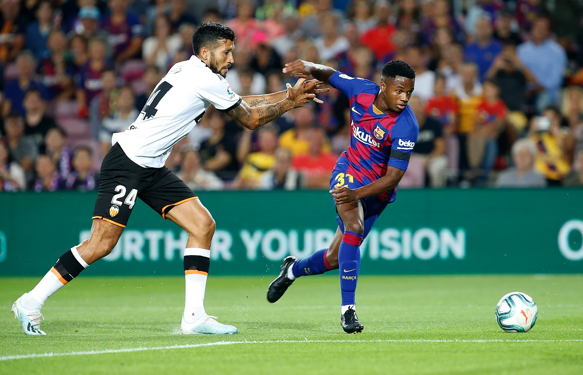 Valencia’s Ezequiel Garay, left, fights for the ball with Barcelona’s Ansu Fati, right, during the Spanish La Liga soccer match between FC Barcelona and Valencia CF at the Camp Nou stadium in Barcelona, Spain, Saturday, Sep. 14, 2019. 