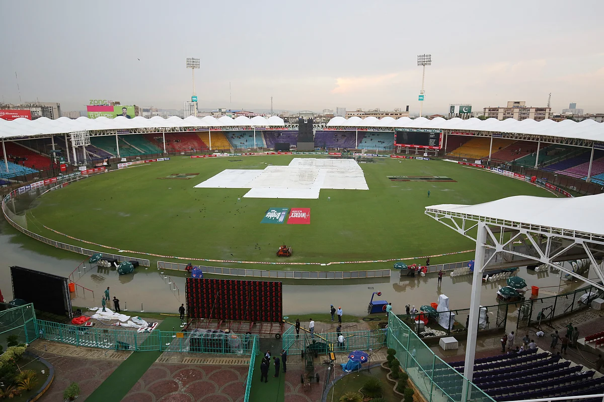 Officials cover the ground of the National Stadium after a rain in Karachi, Pakistan, Friday, Sept. 27, 219. Heavy rain has delayed the start of the first one-day international between Pakistan and Sri Lanka. 