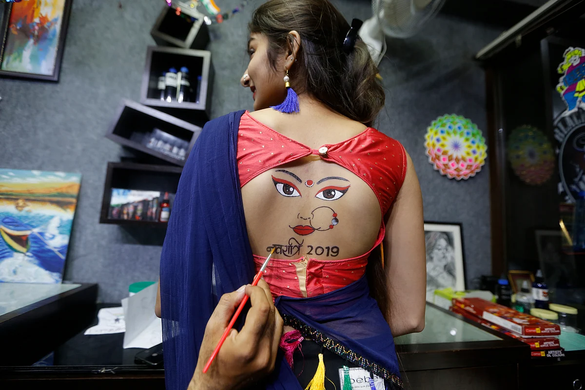 An Indian girl gets tattoo on her back done in preparation of forthcoming Hindu festival Navratri in Ahmadabad, India, Tuesday, 24 September.
