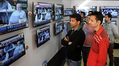 Amritsar: People glued to the television screens as Union Railways Minister Suresh Prabhakar Prabhu presents Railway Budget 2015-16 at the Parliament, in Amritsar, on Feb 26, 2015. (Photo: IANS)