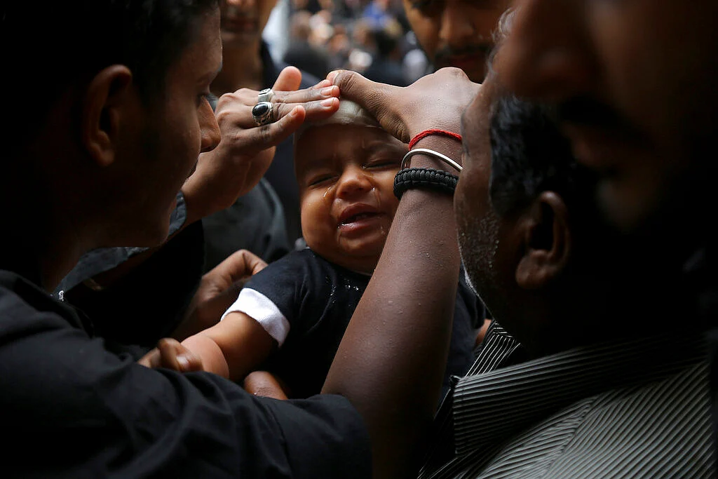 Shiite Muslim child cries after he was given a cut on the forehead during an Ashoura procession in Hyderabad, Telangana.