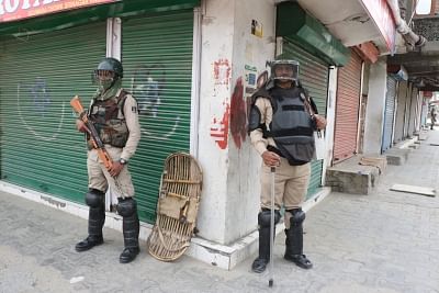 Srinagar: Security personnel stand guard as shops remain shut during a separatist-called protest shutdown over civilian deaths during an anti-terror operation, in Srinagar on May 17, 2019. (Photo: IANS)