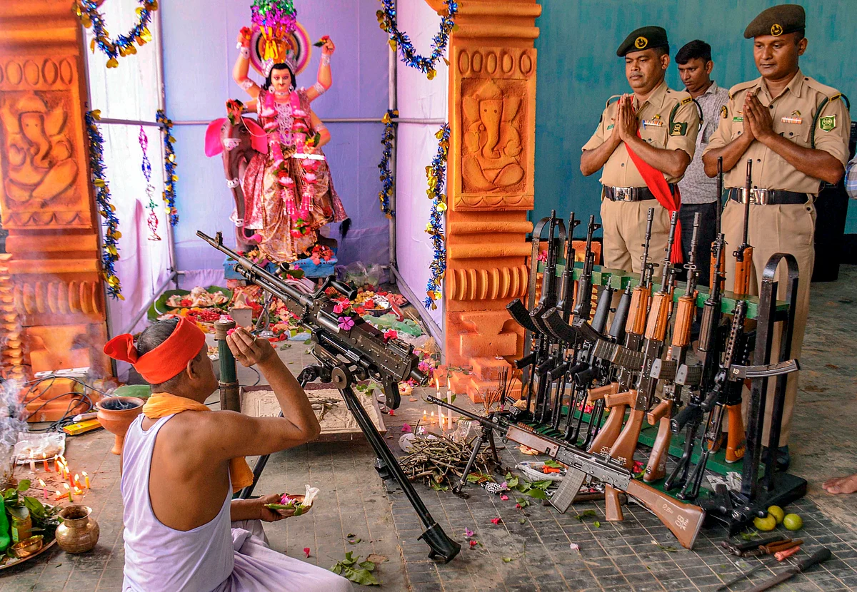 A priest performs worship of weapons on the occasion of Vishwakarma Puja at 2nd Tripura State Rifles Battalion at Bodhjungnagar, Agartala. 