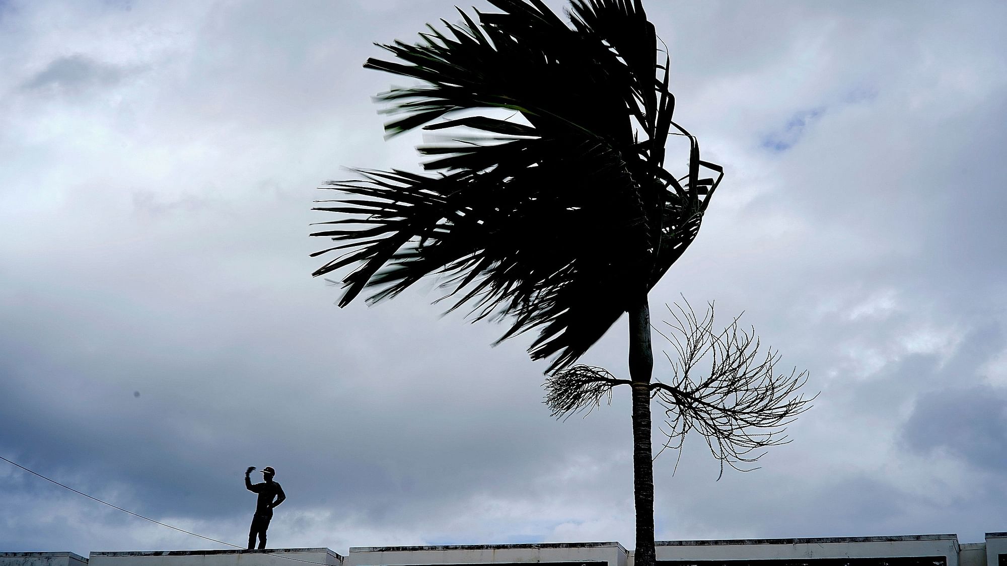 A man stands on a store’s roof as he works to prepare it for the arrival of Hurricane Dorian in Freeport on Grand Bahama, Bahamas.