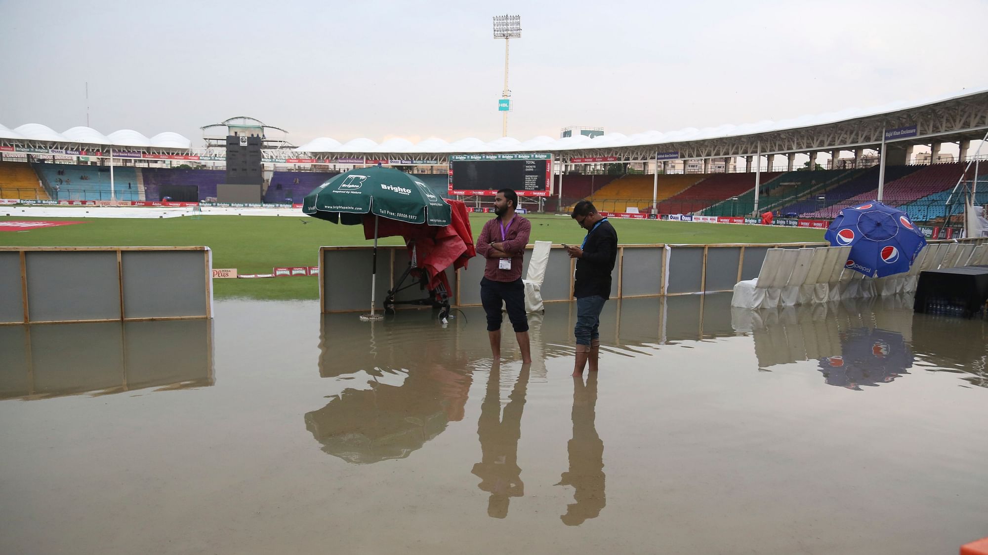 Officials stand at the National Stadium after rain in Karachi, Pakistan, Friday, Sept. 27, 219. Heavy rain has delayed the start of the first one-day international between Pakistan and Sri Lanka.&nbsp;