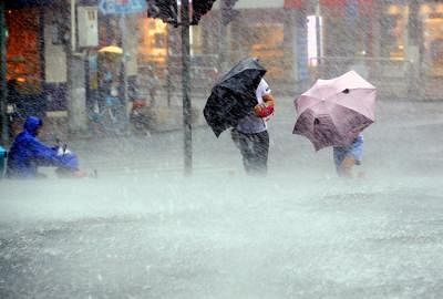 SHANGHAI, Aug. 10, 2019 (Xinhua) -- Pedestrians walk against heavy rain on Xinsong Road in Shanghai, east China, Aug. 10, 2019. The Shanghai central meteorological station updated the yellow alert for heavy rain to orange alert on Saturday afternoon, as Typhoon Lekima landed in east China