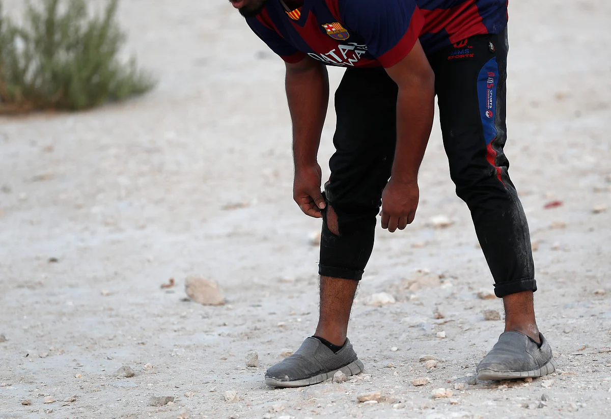 A man takes position to field during a game of cricket on a patch of wasteland in Doha, Qatar, Friday, Oct. 4, 2019. 