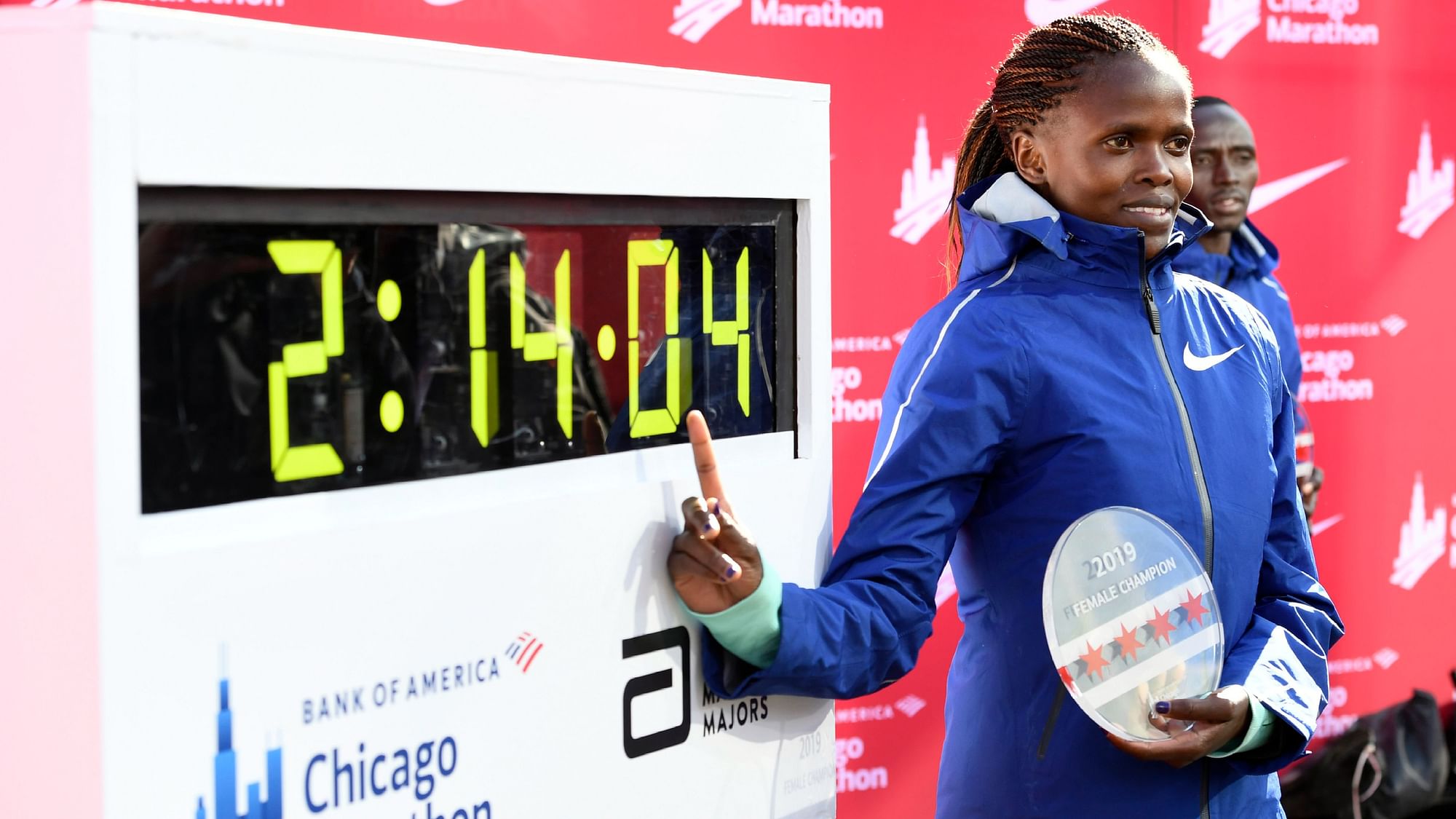 Brigid Kosgei of Kenya, poses with her time after winning the Women’s Bank of America Chicago Marathon while setting a world record of 2:14:04, Sunday, 13 October, 2019, in Chicago.