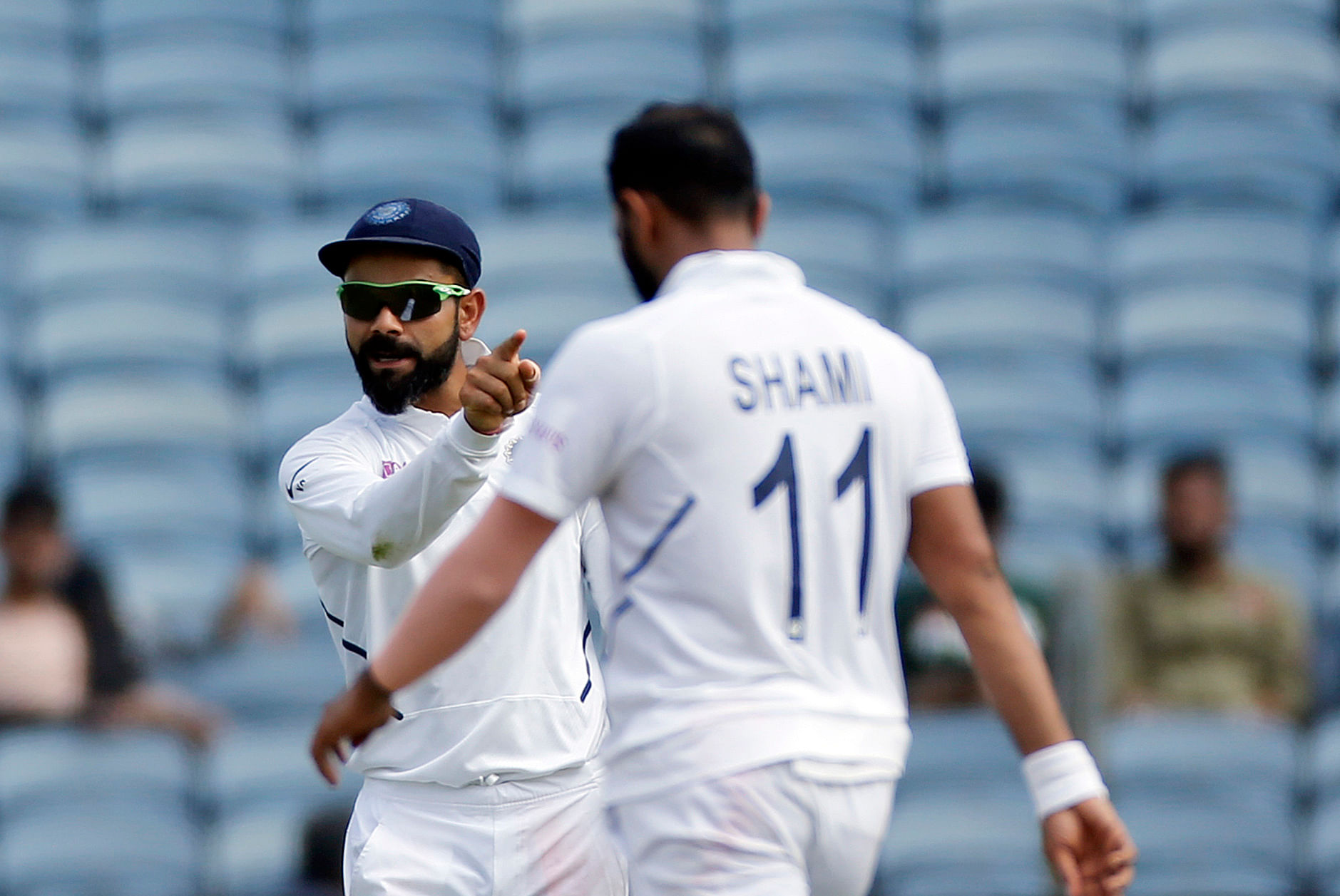Indian cricket team captain Virat Kohli celebrates a wicket with Mohammed Shami.