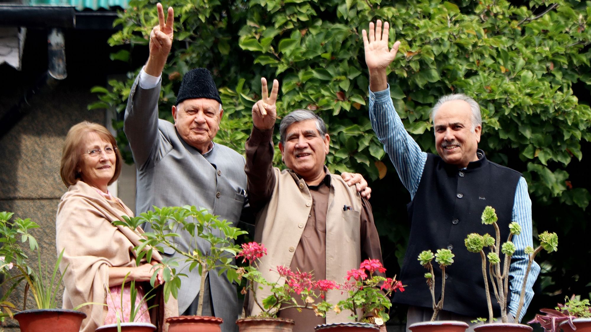 National Conference President Farooq Abdullah, his wife Molly Abdullah, party leaders Mohammad Akbar Lone and Hasnain Masoodi wave towards media persons at their residence in Gupkar, Srinagar, Sunday, 6 October.