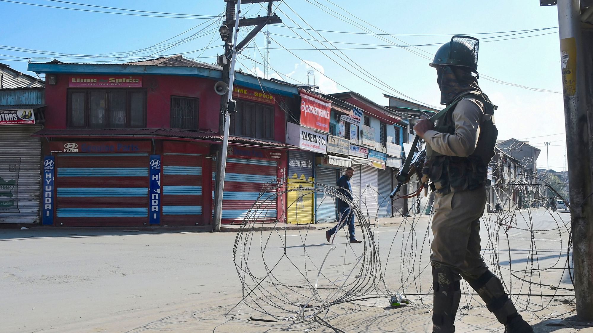 A security personnel stands guard during restrictions, in Srinagar. Mobile postpaid connectivity will be restored today, the J&amp;K administration has said.