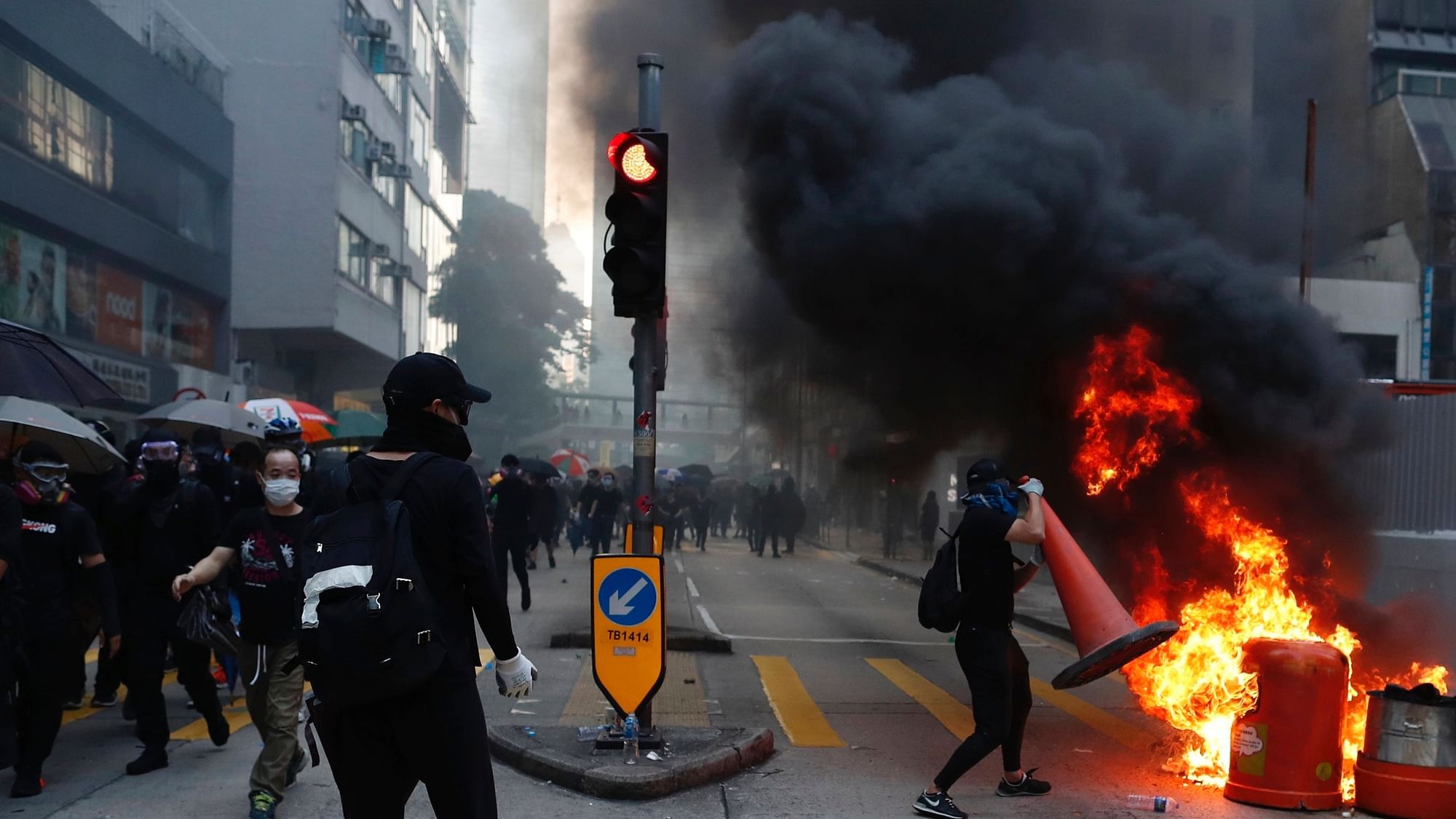 Anti-government protesters set fire to block traffic in Hong Kong.