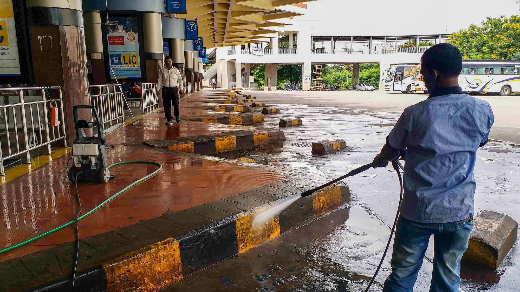 A worker cleans an empty bus depot during a bandh called by Telangana RTC employees.