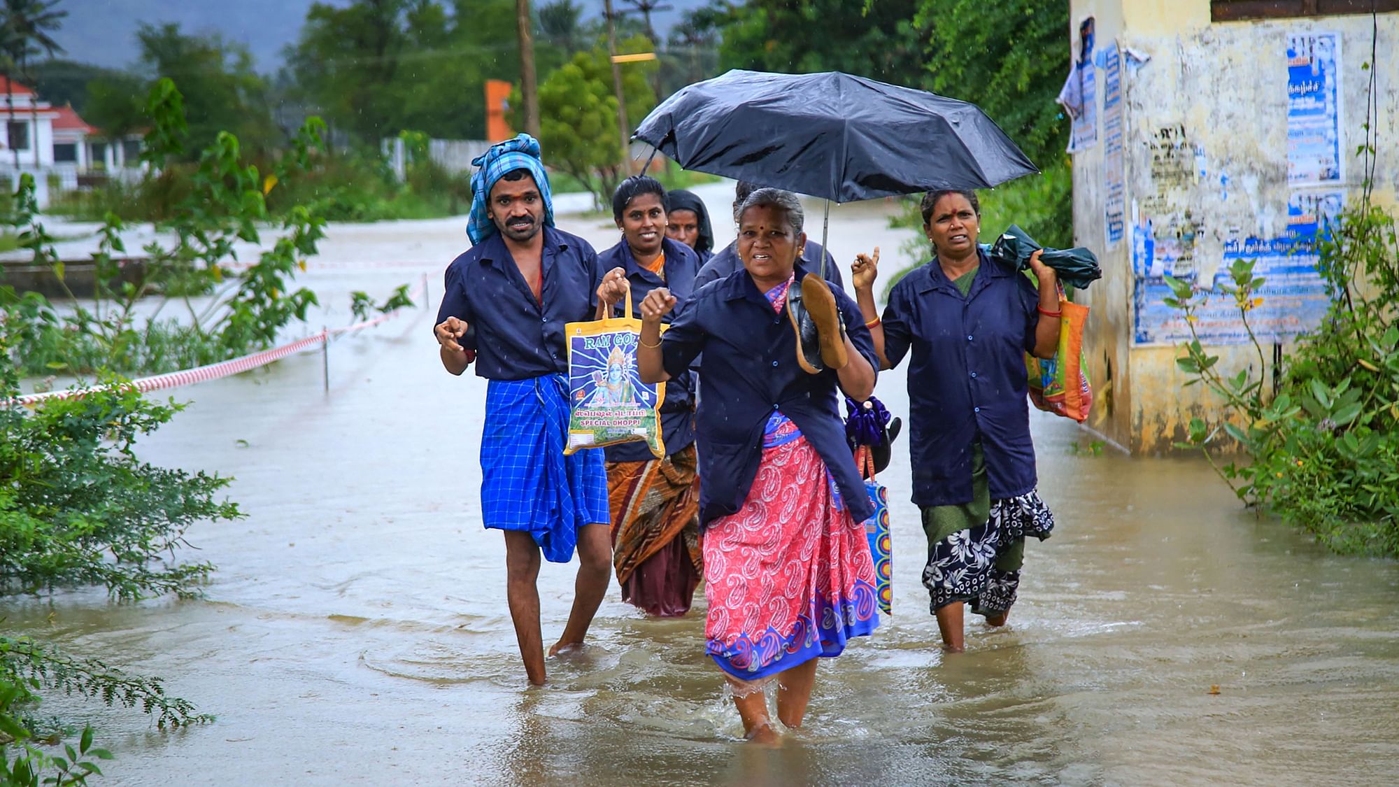 Residents wade through a flooded road after heavy rains at Nagercoil in Kanyakumari district on Monday, 21 October.