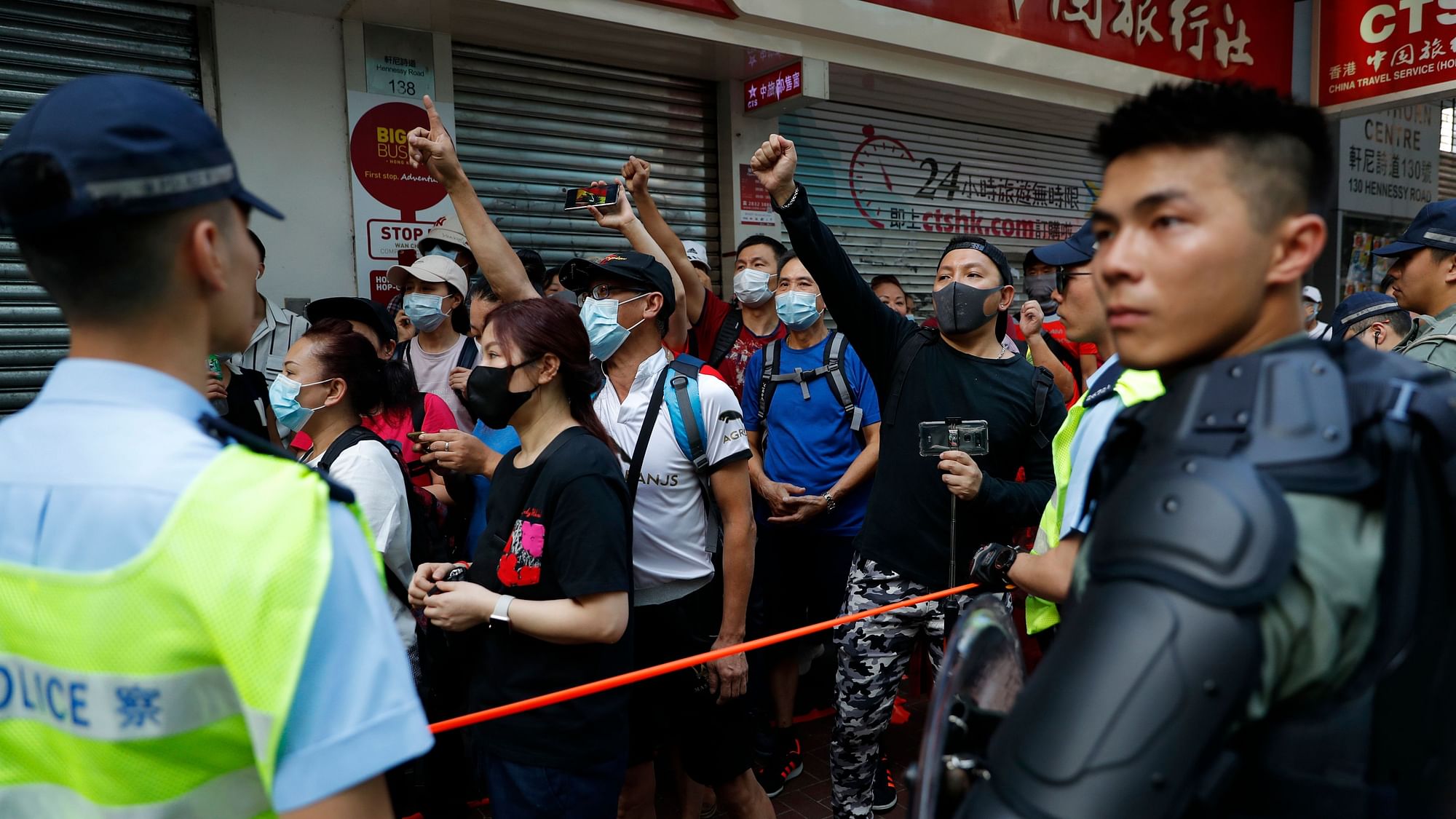 Police watch as anti-government protesters march in Wang Chai district, Tuesday, 1 October.