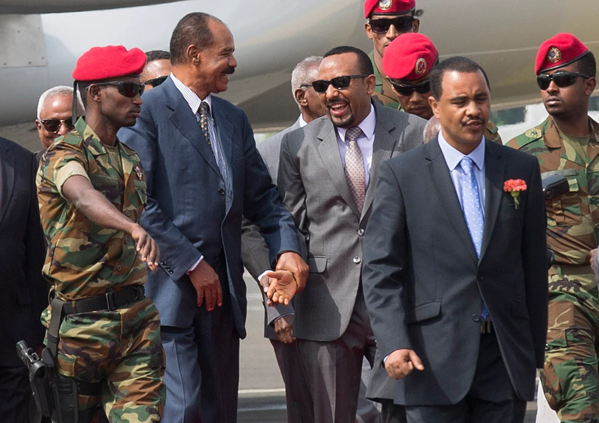 Eritrean President Isaias Afwerki, center left, is welcomed by Ethiopia’s Prime Minister Abiy Ahmed, center right, upon his arrival at Addis Ababa International Airport, Ethiopia. Once official rivals, the leaders of Ethiopia and Eritrea have embraced warmly to the roar of a crowd of thousands at a concert celebrating the end of a long state of war.