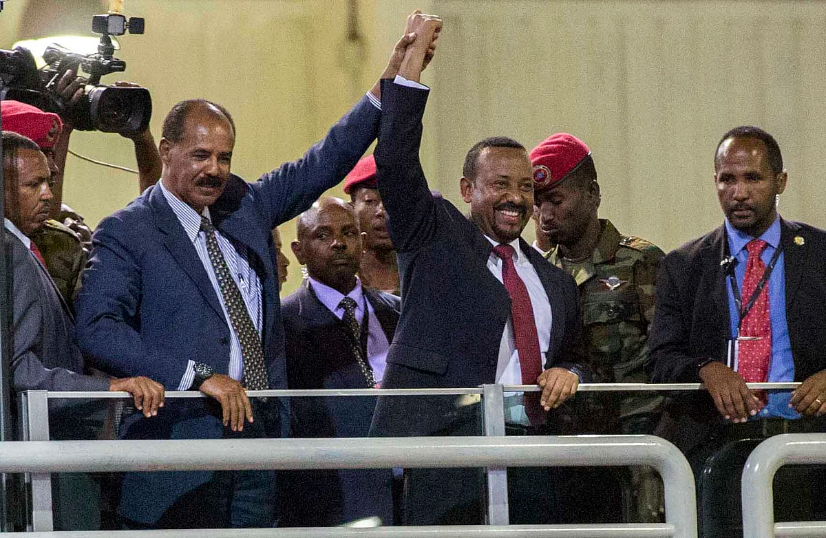 Eritrean President Isaias Afwerki, second left, and Ethiopia’s Prime Minister Abiy Ahmed, center, hold hands as they wave at the crowds in Addis Ababa, Ethiopia. Once official rivals, the leaders of Ethiopia and Eritrea have embraced warmly to the roar of a crowd of thousands at a concert celebrating the end of a long state of war.