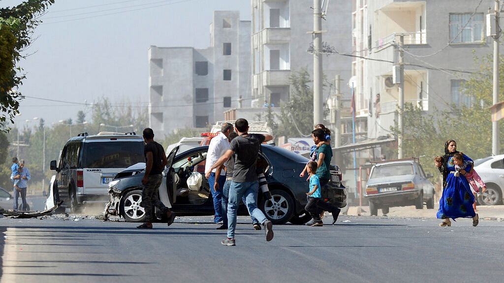 People run to take cover after mortars fired from Syria, in Akcakale, Turkey.