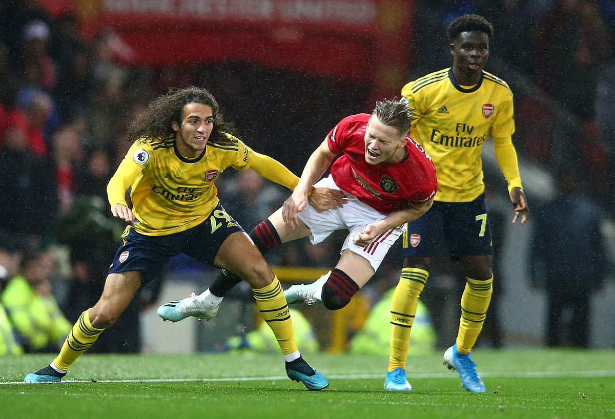 Manchester United’s Scott McTominay, centre, vies for the ball with Arsenal’s Matteo Guendouzi, left, during the English Premier League soccer match.