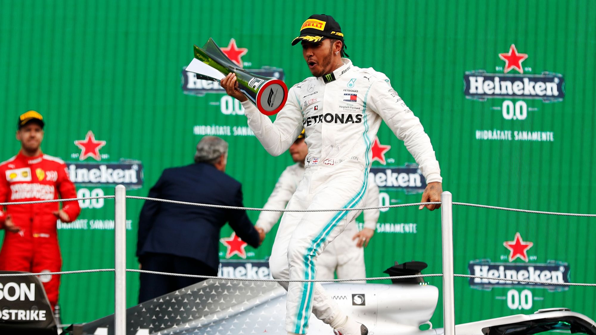 Mercedes driver Lewis Hamilton celebrates on the podium after winning