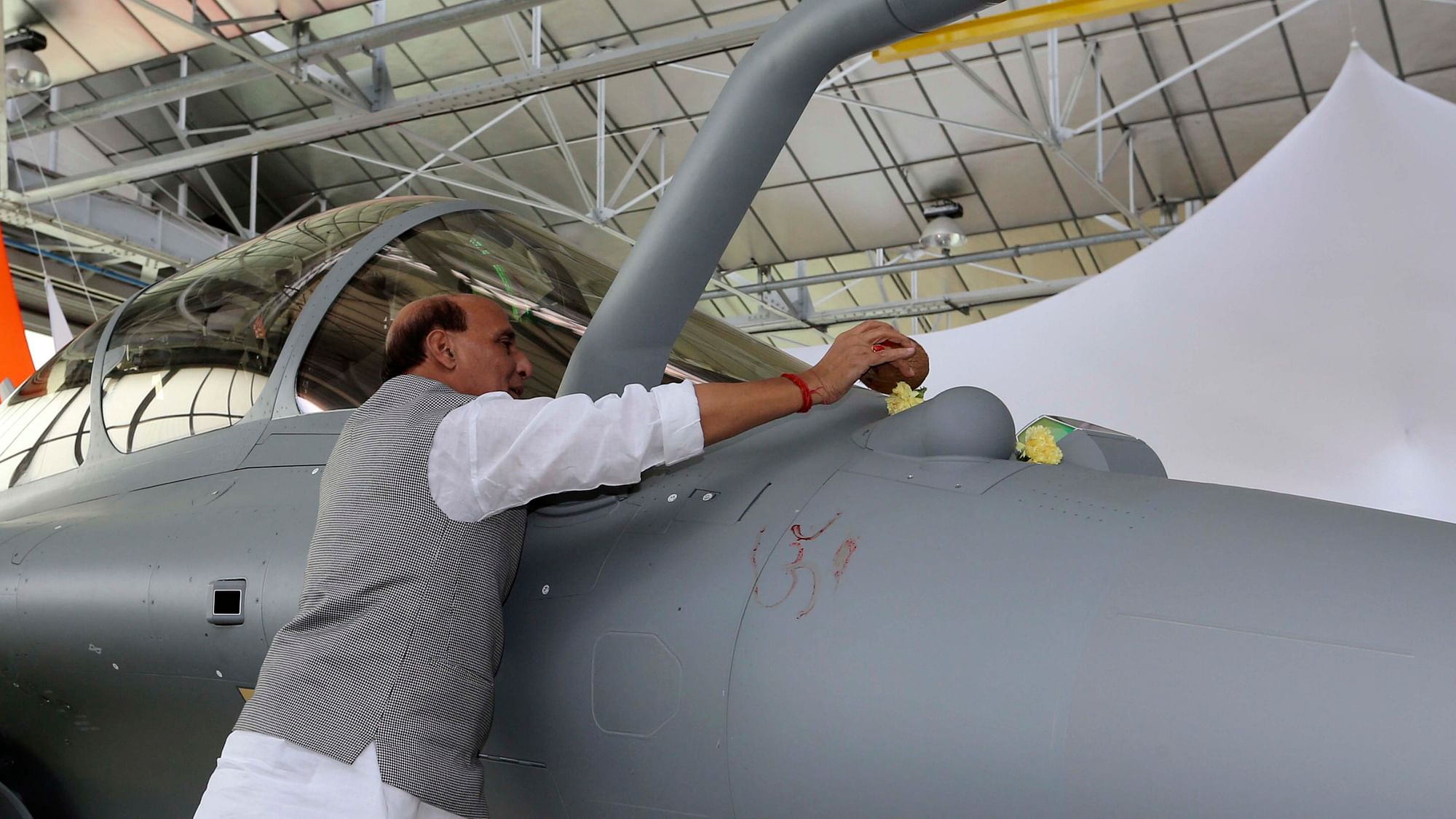 Defense Minister Rajnath Singh put some flowers as a ritual gesture on a Rafale jet fighter during an handover cermony at the Dassault Aviation plant in Merignac, near Bordeaux, southwestern France, on 8 October.