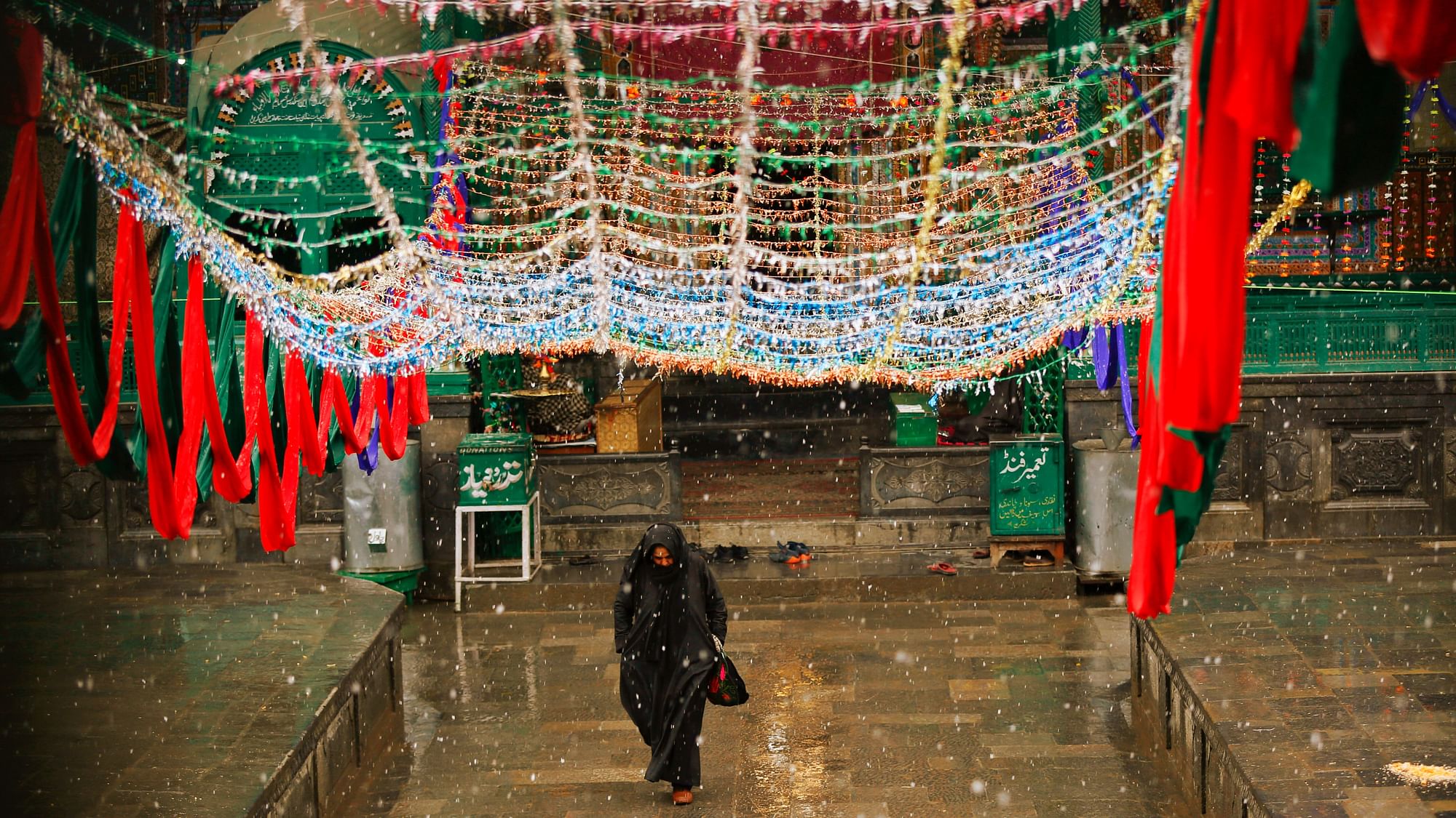 A Kashmiri Muslim woman walks outside a Muslim shrine as it rains in Srinagar. (Image used for representational purposes.)