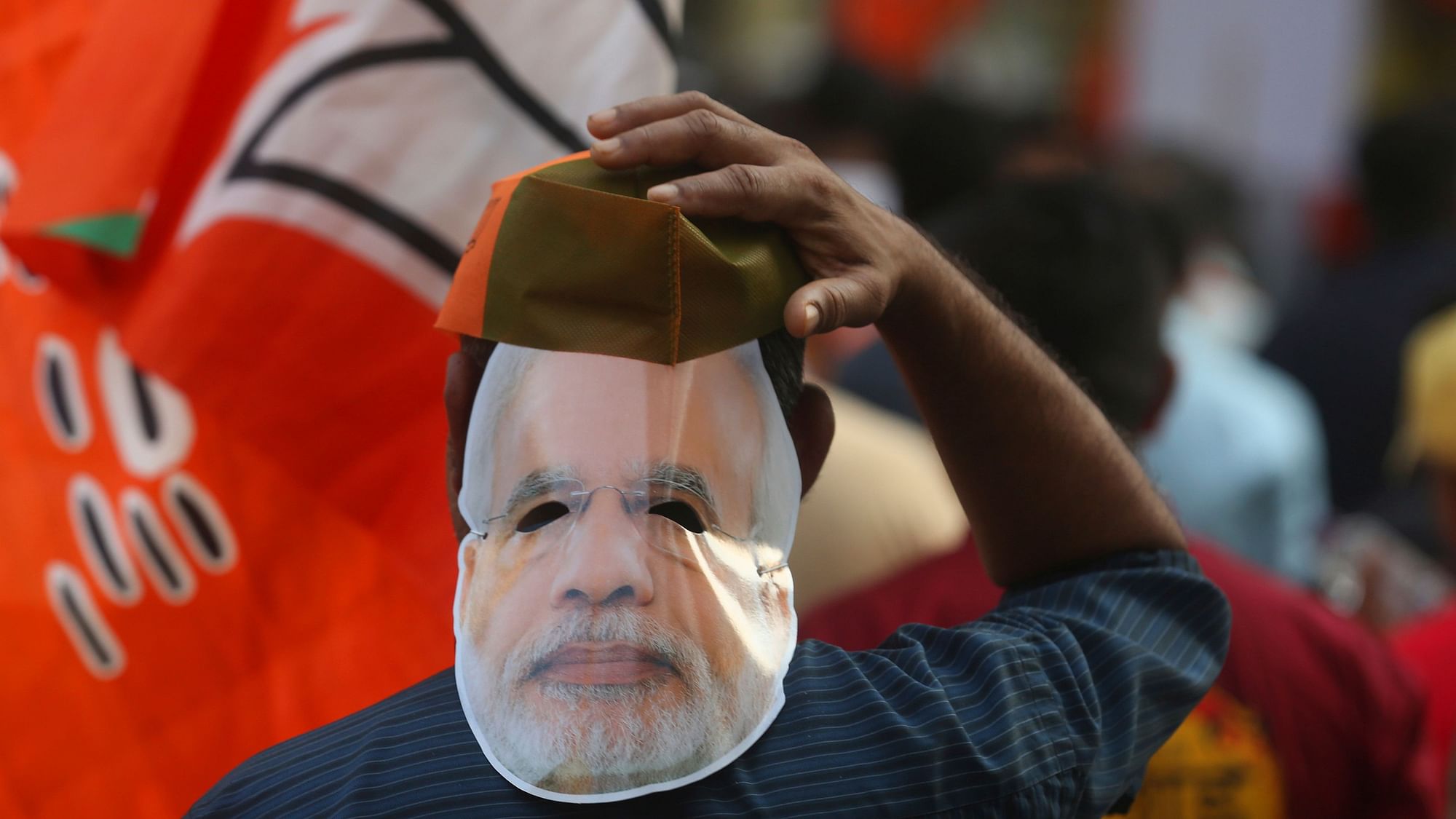 A supporter of Bharatiya Janata Party wearing a mask of Prime Minister Narendra Modi participates in an election campaign rally in Mumbai, India.&nbsp;