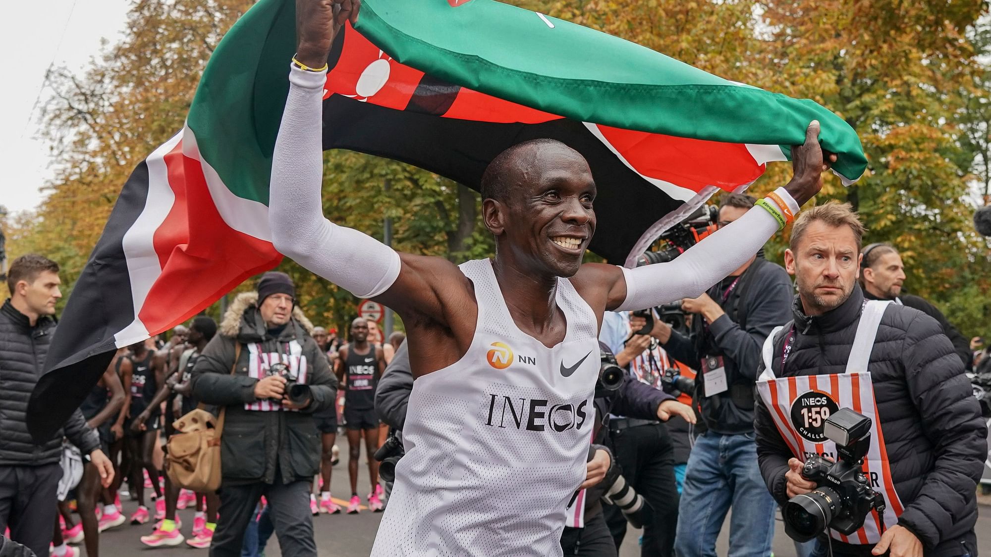 Eliud Kipchoge celebrates with the Kenyan flag after breaking the historic two hour barrier for a marathon in Vienna, Saturday, Oct. 12, 2019.&nbsp;