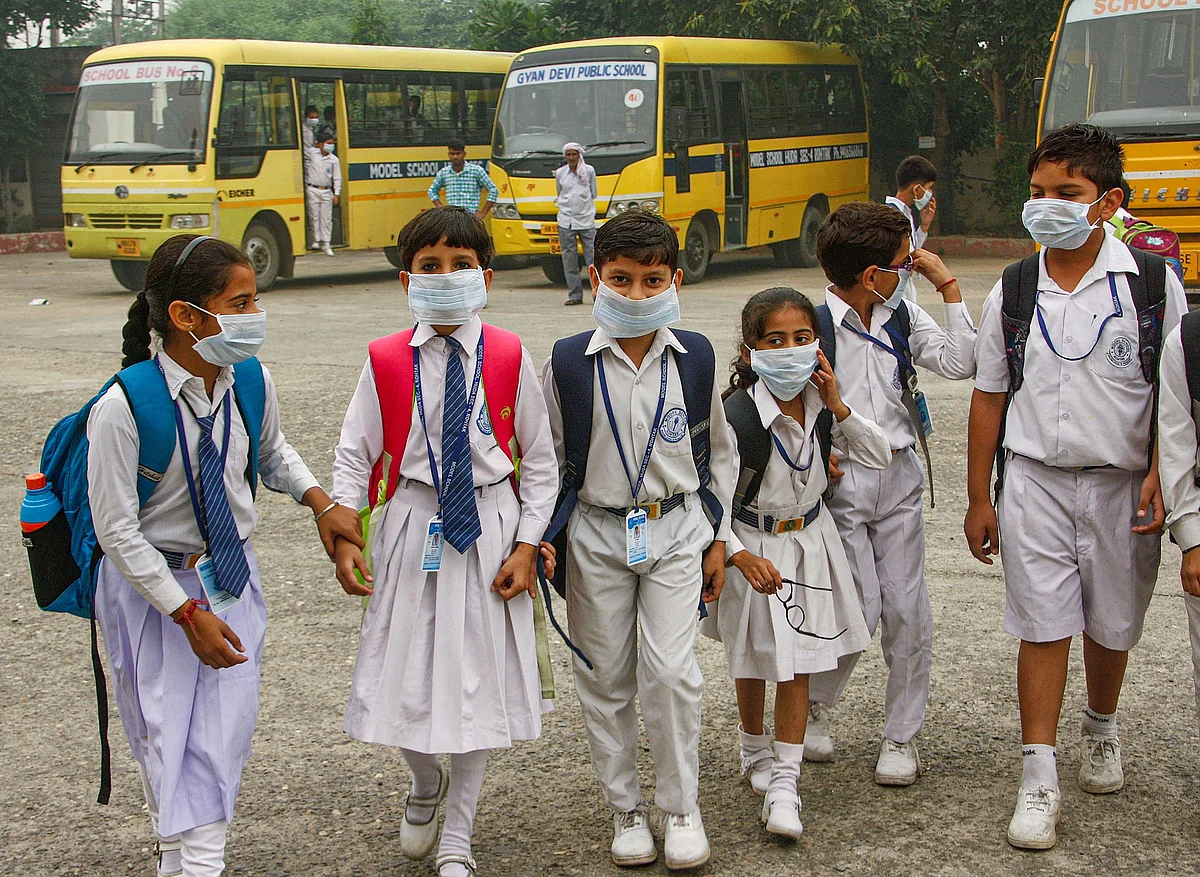 Students wearing mask walk amid an atmoshphere shrouded in smog in Rohtak, Saturday, 2 November 2019.