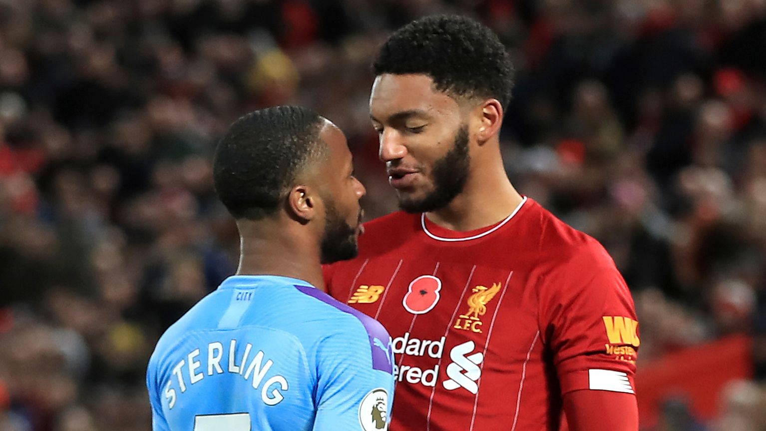 Liverpool’s Joe Gomez, right, and Manchester City’s Raheem Sterling clash during the Premier League soccer match at Anfield, Liverpool.