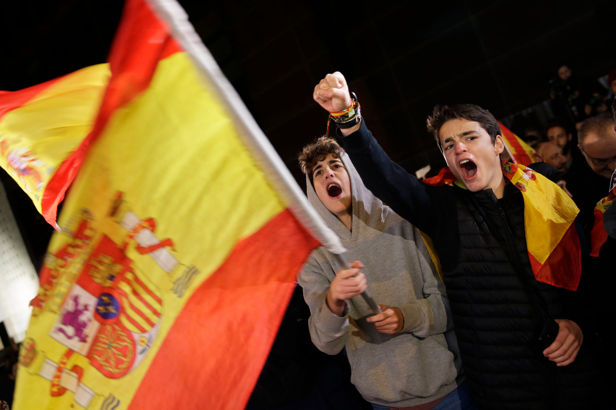 Spain’s far-right Vox party supporters cheer outside the party headquarters after the announcement of the general election first results, in Madrid.