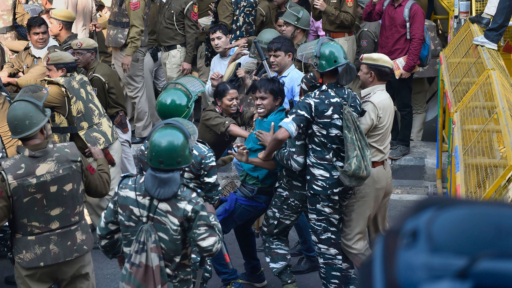 CRPF personnel attempt to stop a JNU student from crossing the barricades during a protest march towards Parliament, on the first day of the Winter Session, in New Delhi, Monday 18 November.