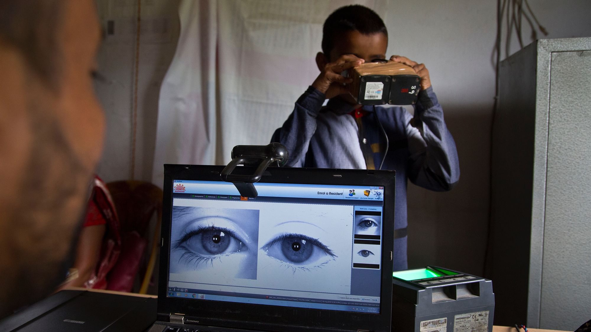 A National Register of Citizens (NRC) officer takes a photograph of the eyes of a boy at an NRC center.&nbsp;