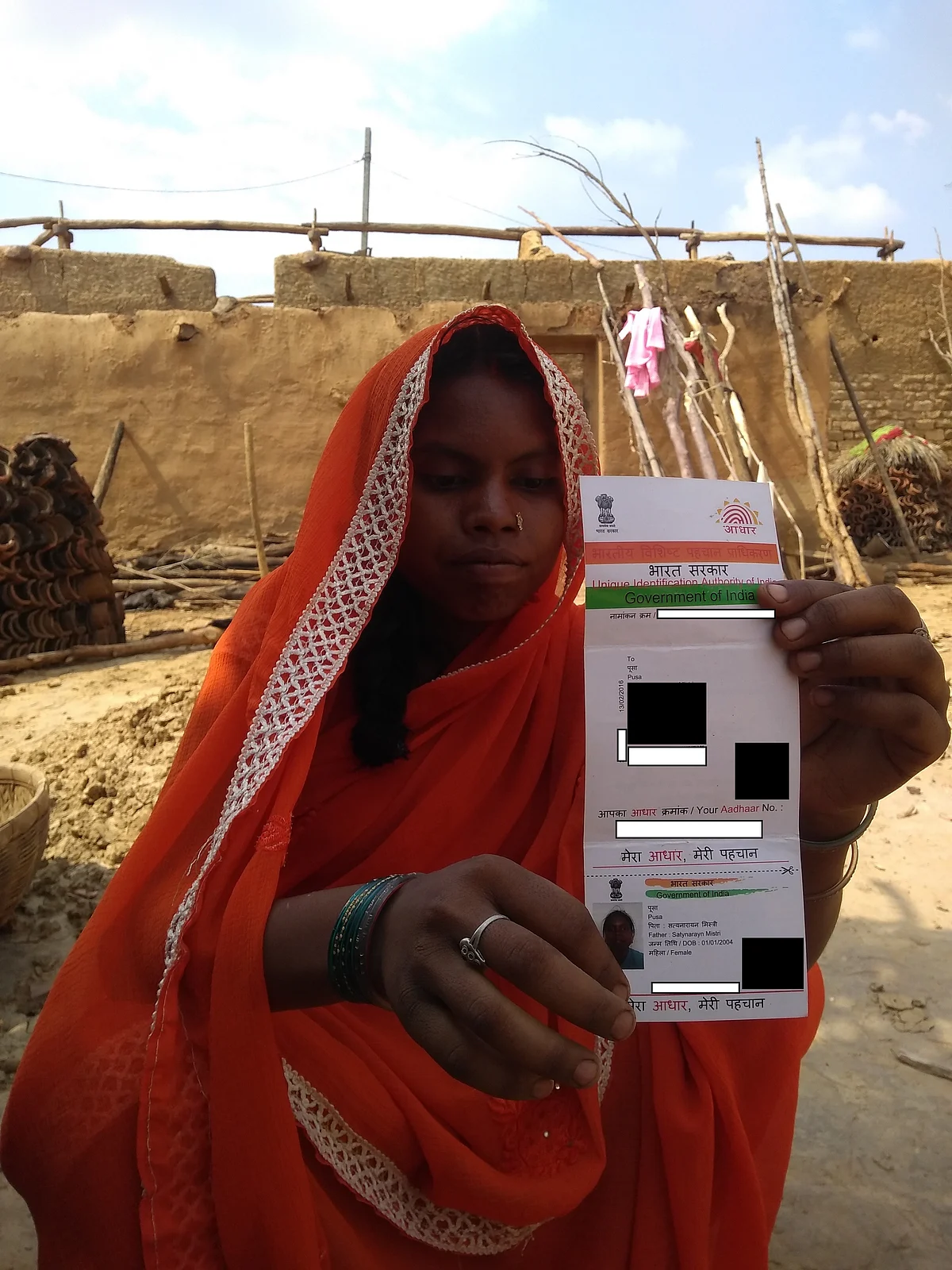 Usha Devi holding her Aadhaar card in which her name has been mistakenly mentioned as ‘Pusa’.
