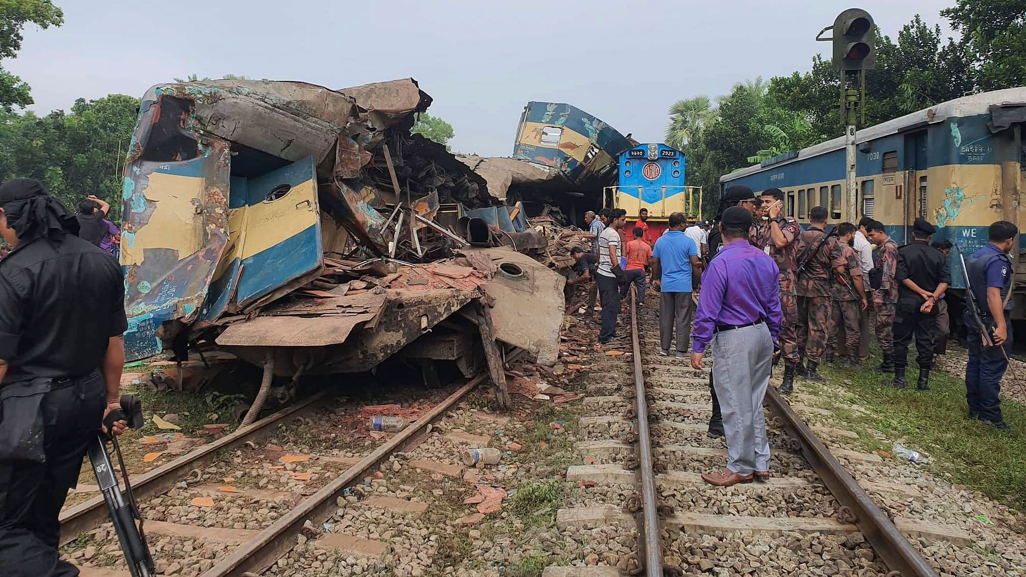 People gather near badly damages coaches after two speeding trains collided in in Brahmanbaria district, 82 kilometers (51 miles) east of the capital, Dhaka.