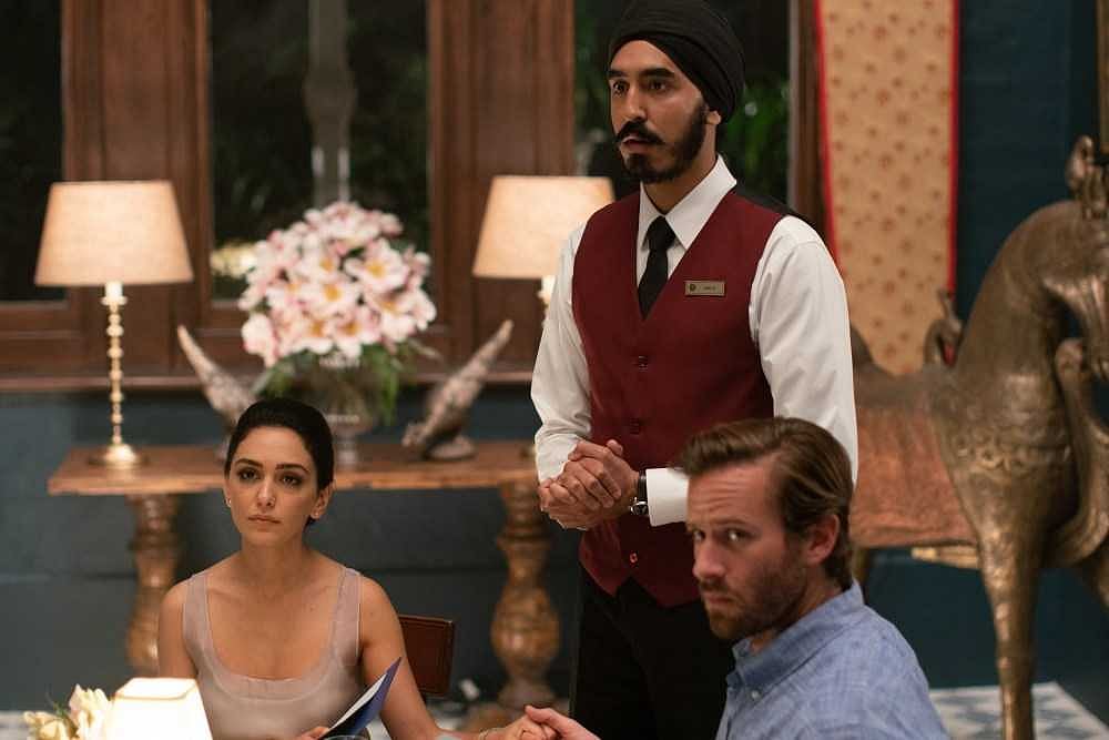 Dev Patel as a staff member with Armie Hammer and Nazanin Boniadi as guests in <i>Hotel Mumbai</i>.