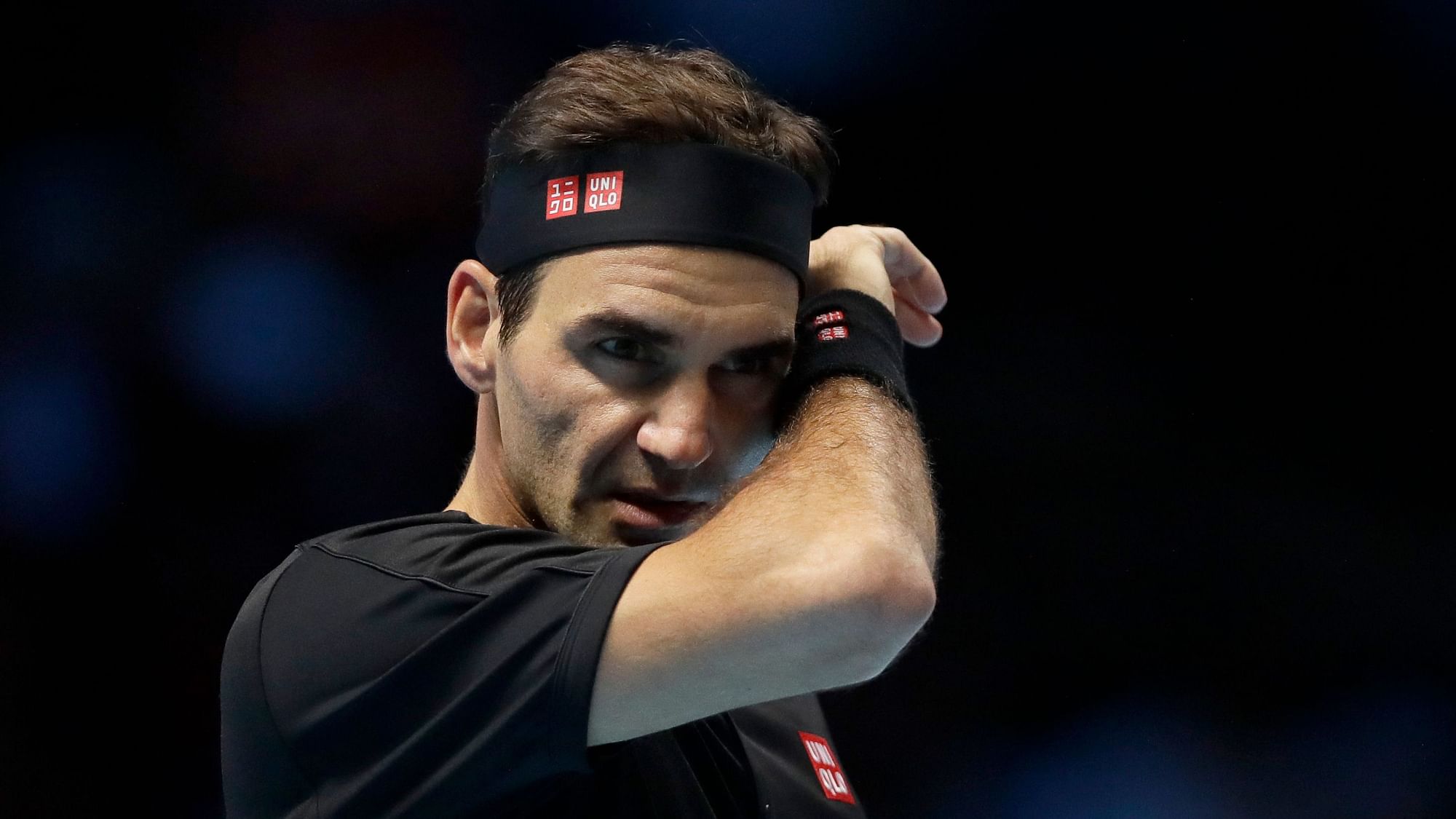 Roger Federer of Switzerland wipes his face after he plays a return to Stefanos Tsitsipas of Greece during their ATP World Tour Finals semifinal tennis match at the O2 Arena in London, Saturday.